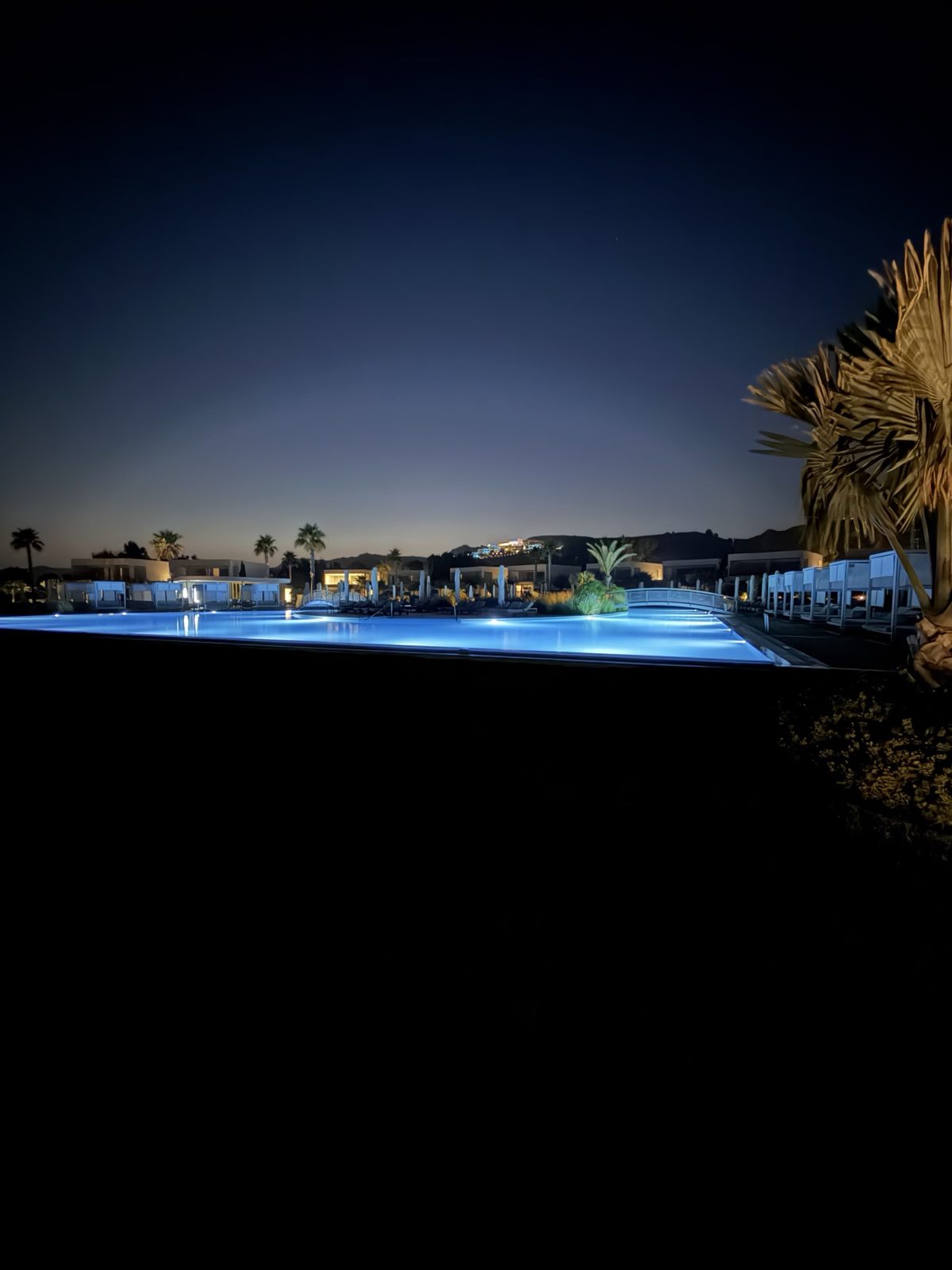 La piscina grande di Ikos Aria illuminata la sera