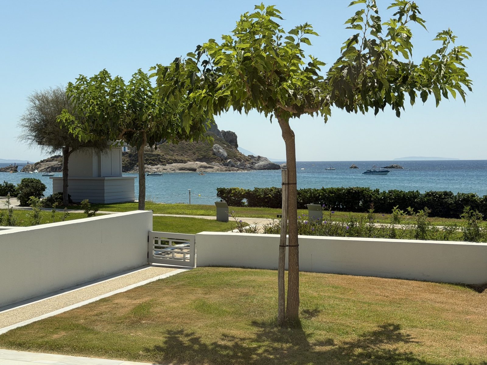 Il giardino privato della suite con il cancelletto verso la spiaggia e Kastri sullo sfondo